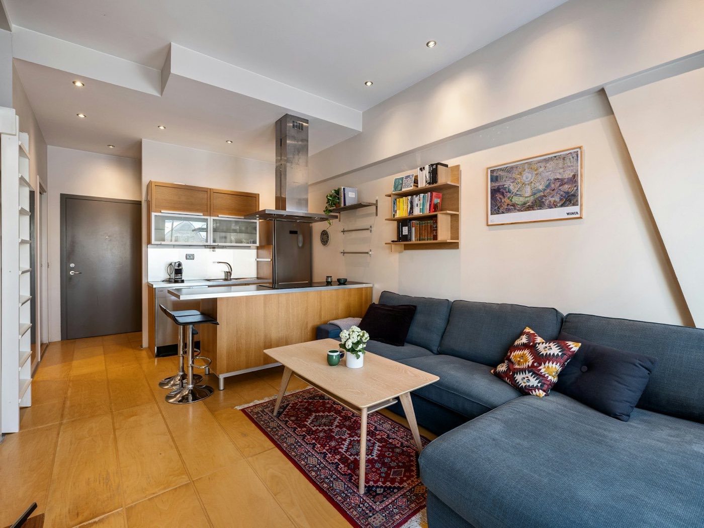 Small suite with a sofa, coffee table and a compact kitchen along the back wall